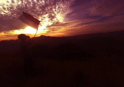 Silhouette man standing against orange sky