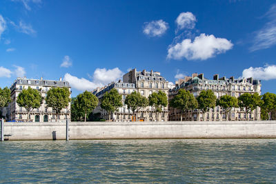 Buildings at waterfront  against sky