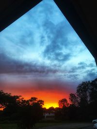 Low angle view of silhouette trees against sky