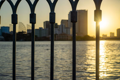 Bokeh of a fence with saigon river and sunset in the background