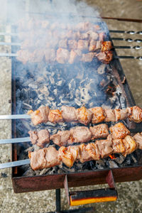 Closeup macro of raw roasted marinated meat barbecue shish kebab shashlik on steel metal skewers 