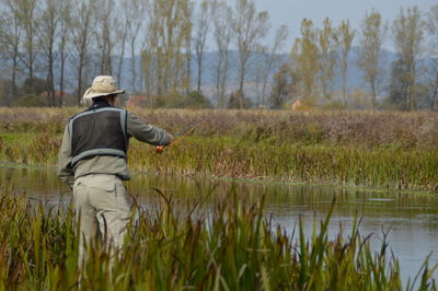 Rear view of man working in grass