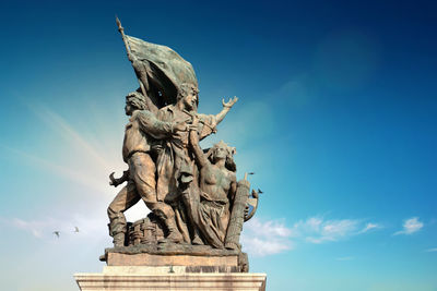 Low angle view of statue against blue sky