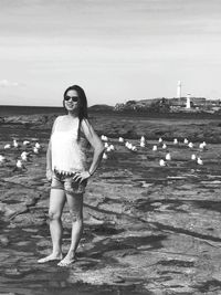 Woman wearing sunglasses while standing on land against sky