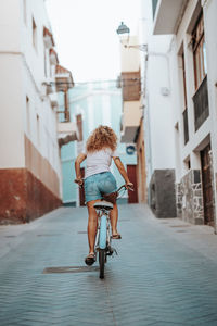 Rear view of woman walking on street in city