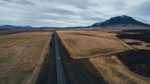 Scenic view of road by mountains against sky