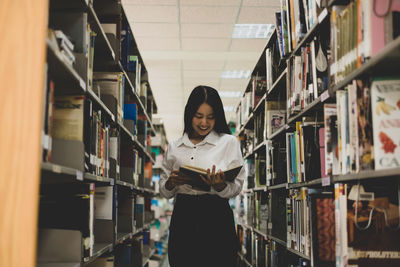 Portrait of young woman standing in library