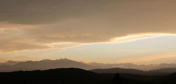 Scenic view of silhouette mountains against sky at sunset
