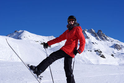 Full length of woman on snowcapped mountain against sky