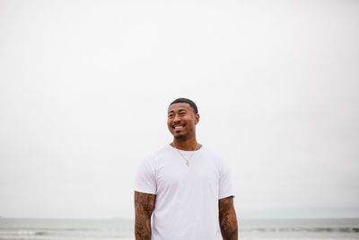 Mixed race man smiling at beach