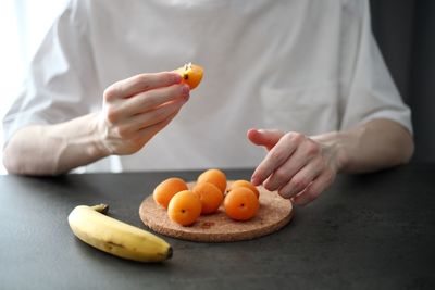 Cropped image of man holding orange fruit