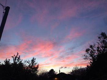 Low angle view of silhouette trees against sky at sunset