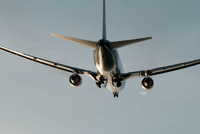 Low angle view of airplane flying against sky