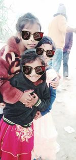 Rear view of friends wearing sunglasses standing outdoors