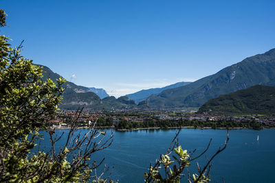 Scenic view of lake and mountains against clear blue sky