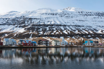 Houses by snowcapped mountains against sky