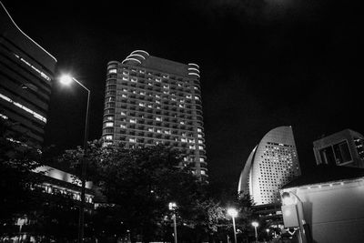 Low angle view of illuminated buildings against sky at night