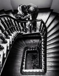 High angle view of man and woman standing on steps in building