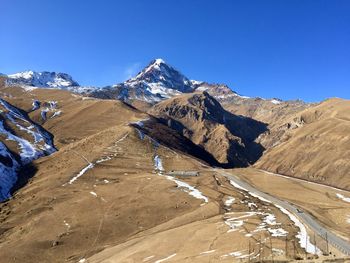 Scenic view of snowcapped mountains against clear blue sky