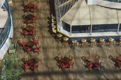 High angle view of empty chairs and tables in restaurant during sunny day