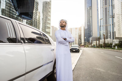 Businessman standing by car while standing on road