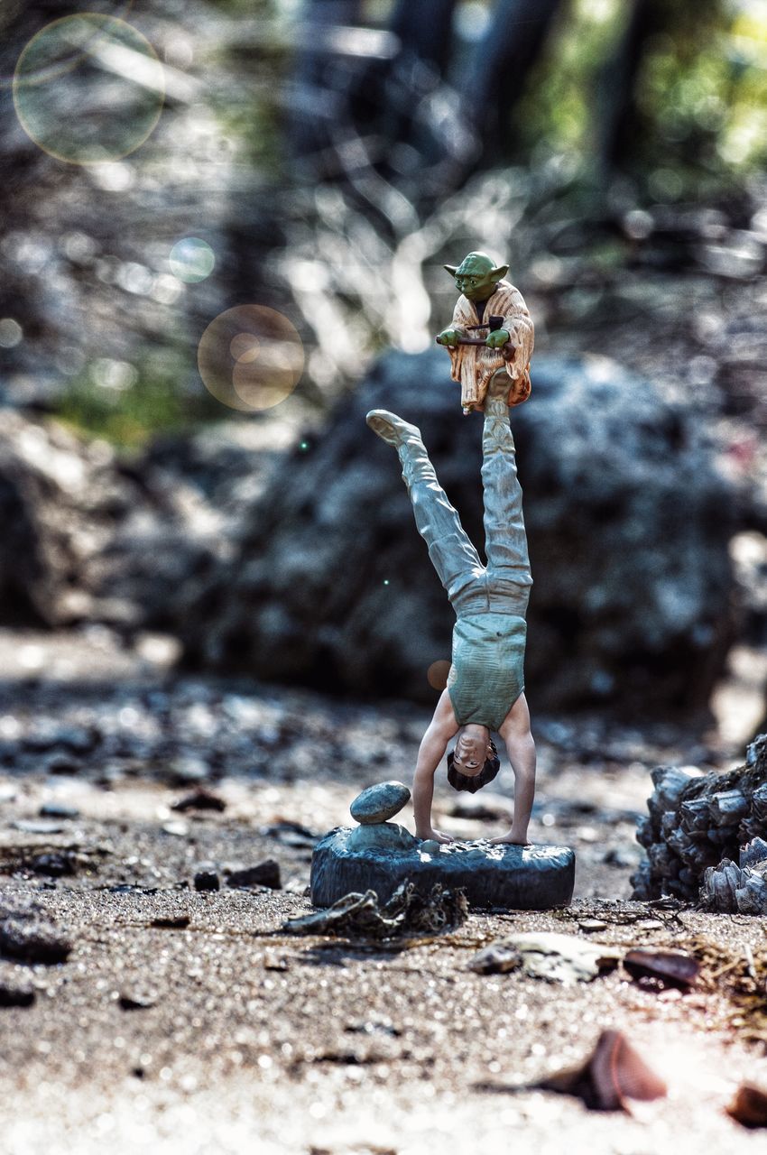 CLOSE-UP OF FIGURINE ON ROCK