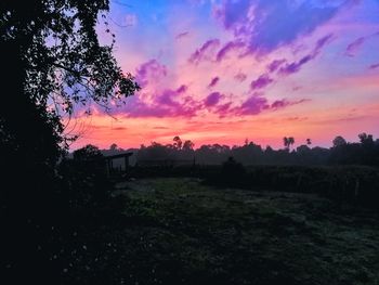 Scenic view of silhouette field against sky during sunset