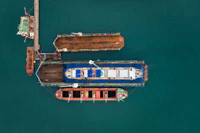 Aerial top view container oil ship in shipyard for repair and maintenance in green sea