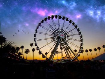 Low angle view of ferris wheel against cloudy sky
