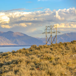 Scenic view of field by mountains against sky