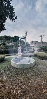 Fountain in park against sky