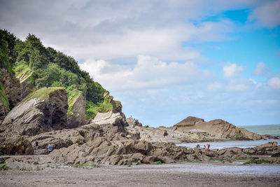 Scenic view of cliffs against cloudy sky