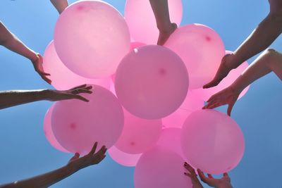 Low angle view of pink balloons against sky