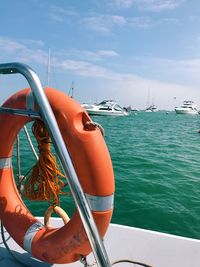 Close-up of boat sailing in sea against sky