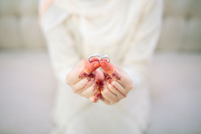 Close-up of bride hands showing wedding rings outdoors