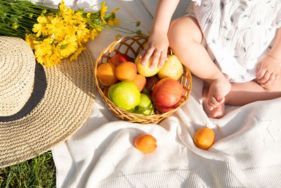 Midsection of woman picking fruits on table