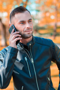 Portrait of young man standing on mobile phone