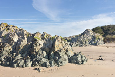 Scenic view of rocks on beach against sky