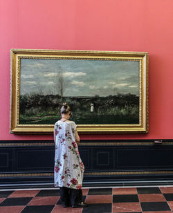 Rear view of woman standing against wall