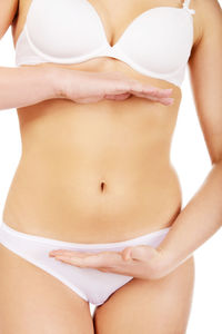 Midsection of woman standing against white background