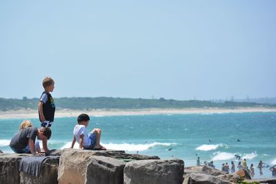 People on beach against clear sky