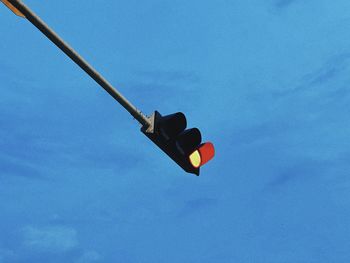 Low angle view of road signal against clear blue sky