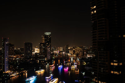 Illuminated buildings in city against sky at night