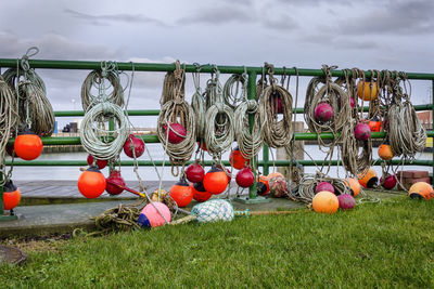 Multi colored umbrellas hanging on field by sea against sky