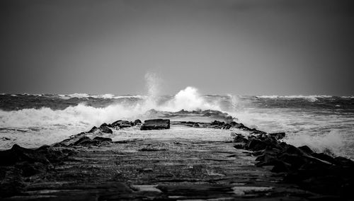 Waves splashing on sea against sky