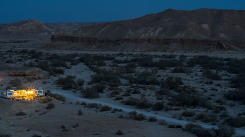 Scenic view of snow covered land and mountains against sky at night