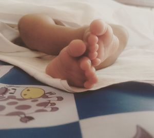 Close-up of baby feet on bed