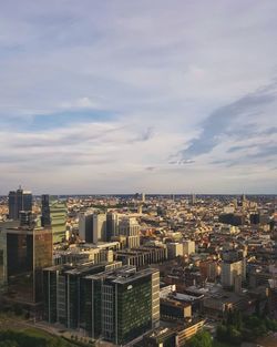 Aerial view of cityscape against cloudy sky