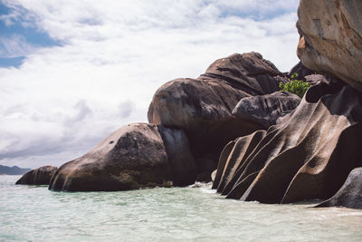 Rock formations on shore against sky