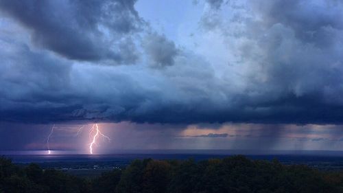 Scenic view of storm clouds over sea at night